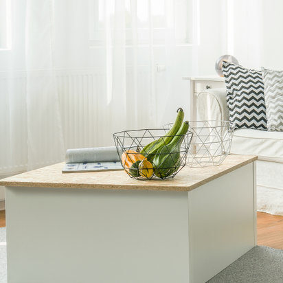 a white and wood coffee table sits in the middle of a living room.